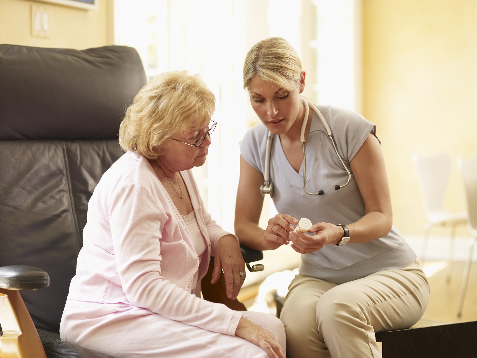 oudere vrouw in gesprek met verpleegster