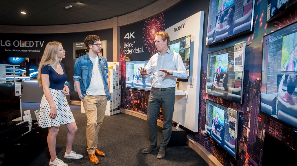 verkoper met twee klanten in TV winkel