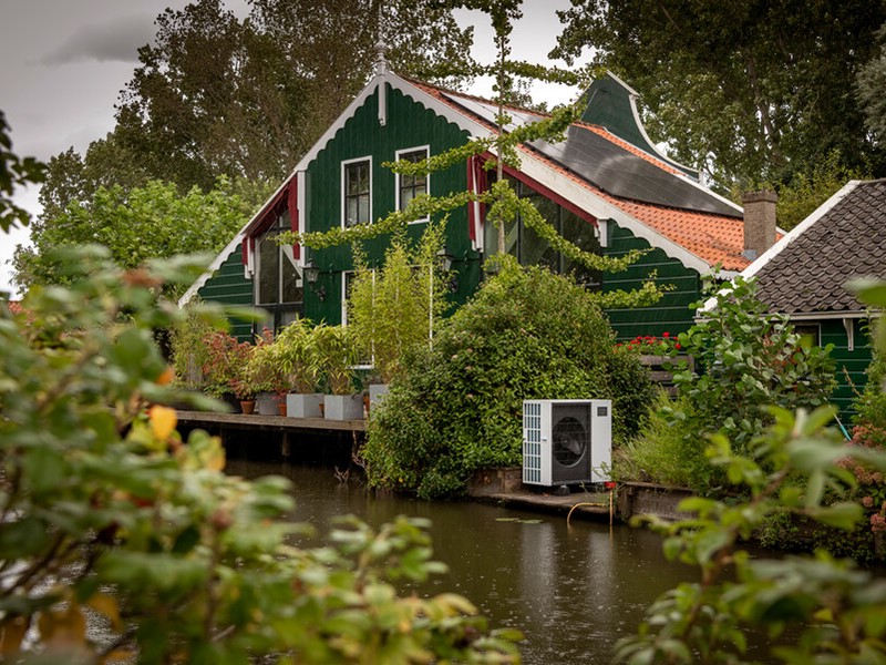 houten huis met zonnepanelen en pomp